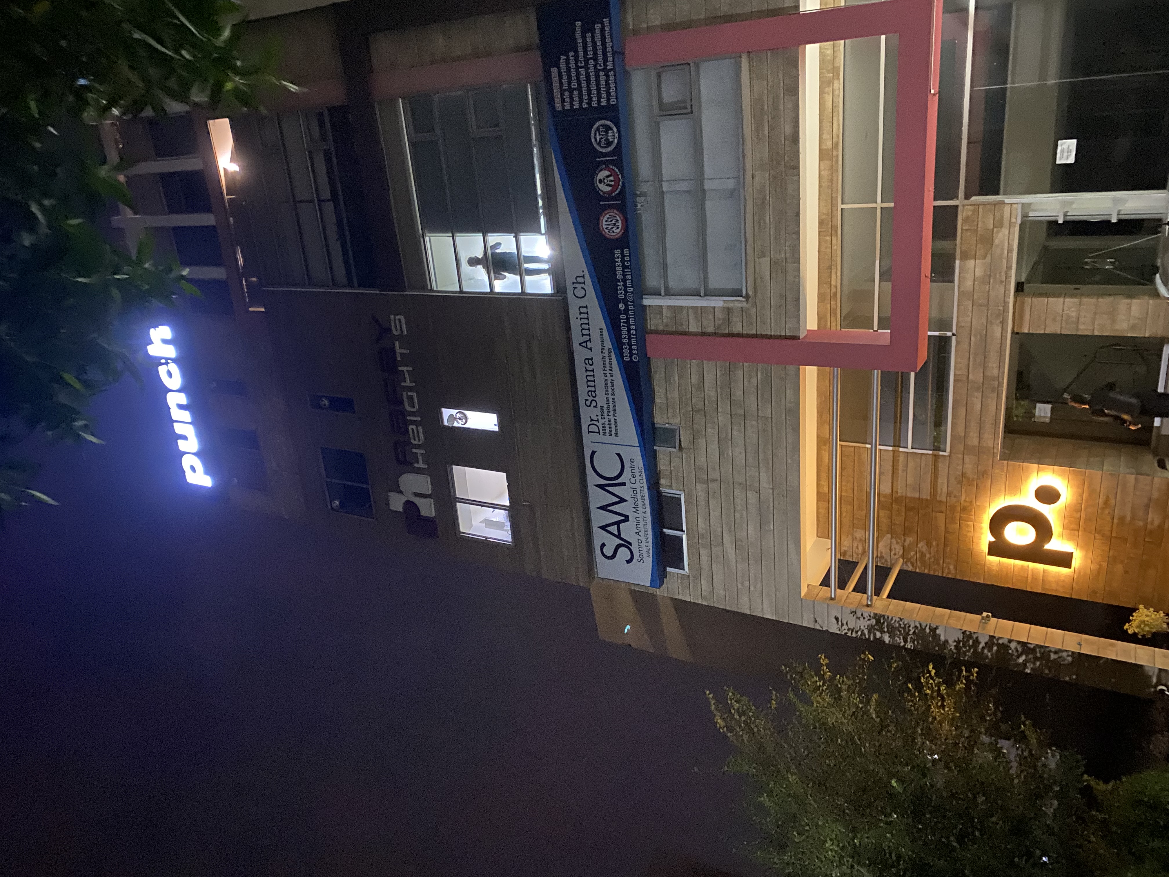 The Punch building at night — the lit punch sign above and the glowing p. at the entrance